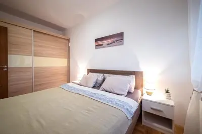 a bedroom with a bed and a closet at Lux Apartmani Rakić in Pirot