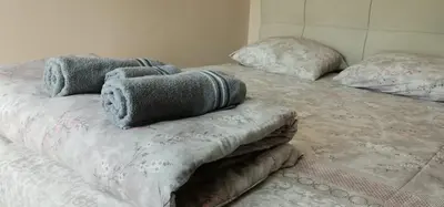 a bed with blankets and pillows on top of it at MAŠA Apartman Vrnjacka Banja in Vrnjačka Banja