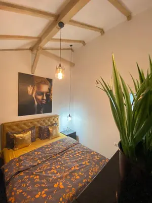 a bedroom with a bed and a potted plant at MERLIN KUĆa in Vrnjačka Banja