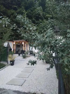 a garden with a stone pathway and a house at MERLIN KUĆa in Vrnjačka Banja