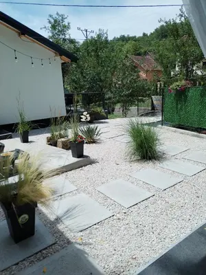 a patio with plants in a yard at MERLIN KUĆa in Vrnjačka Banja