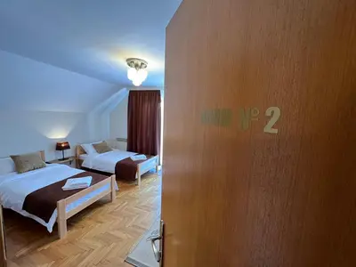 a hotel room with two beds and a door with a sign on it at InterInn Luxury Villa in Paraćin