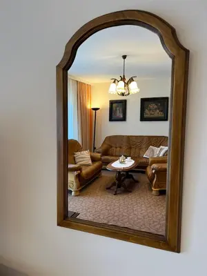 a mirror reflecting a living room with a couch and a table at InterInn Luxury Villa in Paraćin