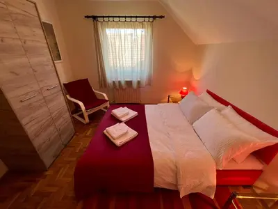 a bedroom with a large bed and a chair at InterInn Luxury Villa in Paraćin