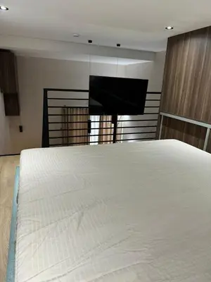 a bedroom with a white bed and a flat screen tv at Woodside Kopaonik Duplex 003 in Kopaonik