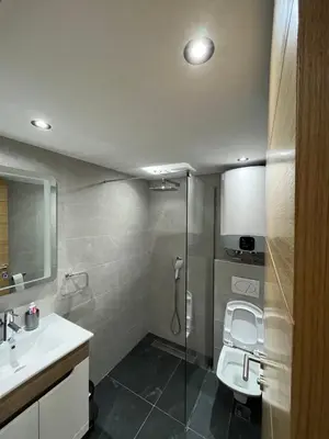 a bathroom with a shower and a toilet and a sink at Woodside Kopaonik Duplex 003 in Kopaonik