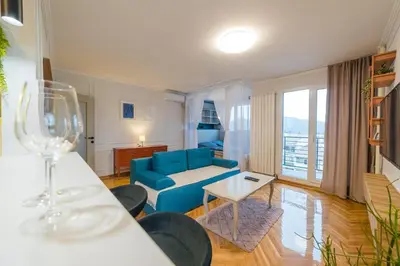 a living room with a blue couch and a table at Apartman Nika in Pirot