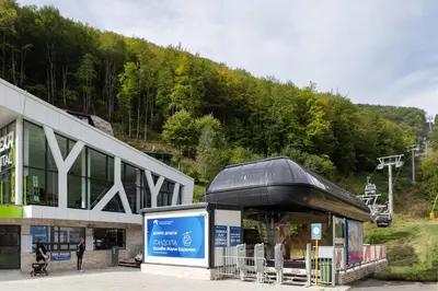 a building in front of a hill with a mountain at Ramonda apartman Vila Bela Reka 50m from Gondola - free parking acces in Brzeće