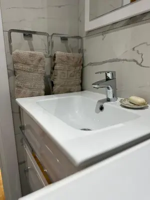 a bathroom with a white sink and towels at Magic Apartments Sokobanja in Soko Banja