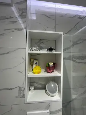a white shelf in a bathroom with marble walls at Magic Apartments Sokobanja in Soko Banja