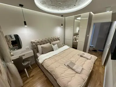 a bedroom with a bed and a desk and a mirror at Magic Apartments Sokobanja in Soko Banja