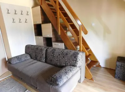 a couch in a living room with a staircase at JollyKop Vila Valentina A14 in Kopaonik