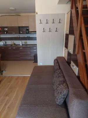 a living room with a couch in front of a kitchen at JollyKop Vila Valentina A14 in Kopaonik