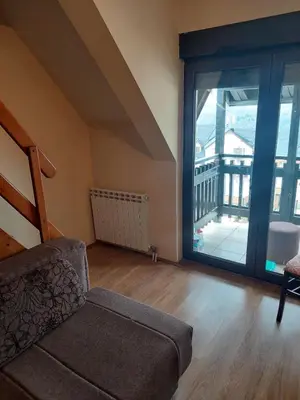 a living room with a couch and a large window at JollyKop Vila Valentina A14 in Kopaonik