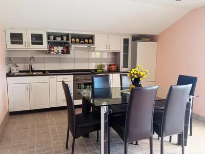 a kitchen with a dining room table and chairs at Apartman Babić in Vrnjačka Banja