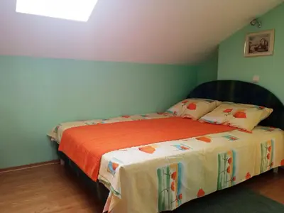 a bedroom with a bed with an orange blanket at Apartman Babić in Vrnjačka Banja