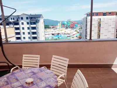 a table and chairs on a balcony with a view of a city at Apartman Babić in Vrnjačka Banja