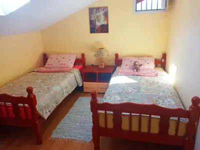 a bedroom with two beds and a table with a lamp at Apartman Babić in Vrnjačka Banja