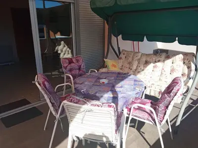a table and chairs with a table and a couch at Apartman Babić in Vrnjačka Banja