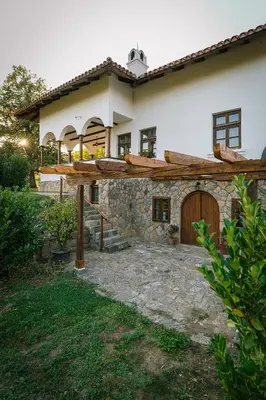a large white house with a wooden door at Eko Zaseok Brana in Rekovac