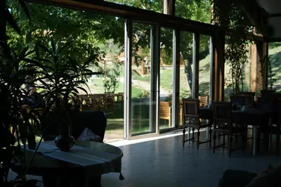 a room with tables and chairs and a large window at Eko Zaseok Brana in Rekovac