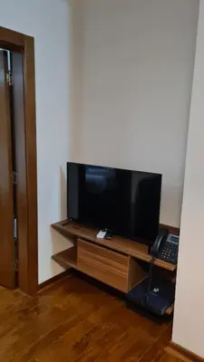 a flat screen tv on a wooden stand with a keyboard at DolceVita Lux & SPA in Vrnjačka Banja