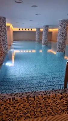 a large swimming pool with blue water in a building at DolceVita Lux & SPA in Vrnjačka Banja