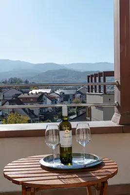 a bottle of wine and two wine glasses on a table at DolceVita Lux & SPA in Vrnjačka Banja