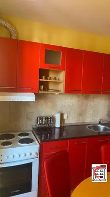 a kitchen with red cabinets and a stove and a sink at Apartman RED u Vrnjačkoj Banji in Vrnjačka Banja