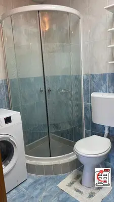 a bathroom with a shower with a toilet and a washing machine at Apartman RED u Vrnjačkoj Banji in Vrnjačka Banja