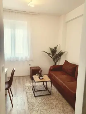 a living room with a brown couch and a table at Apartman N Jagodina in Jagodina