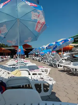 a bunch of chairs and an umbrella on a beach at Apartman N Jagodina in Jagodina