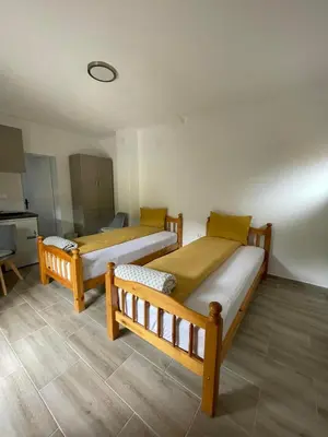 two beds in a room with a kitchen at Apartman Jovanović in Jošanička Banja