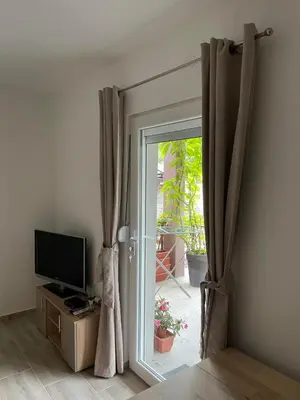 a room with a sliding glass door with a television at Apartman Jovanović in Jošanička Banja