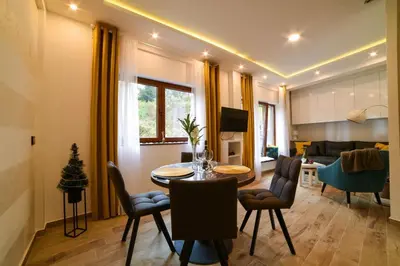 a living room with a table and chairs and a couch at Tontic Lux Milmari in Kopaonik