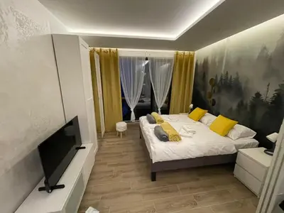 a bedroom with a bed and a flat screen tv at Tontic Lux Residence Hill 53 in Kopaonik