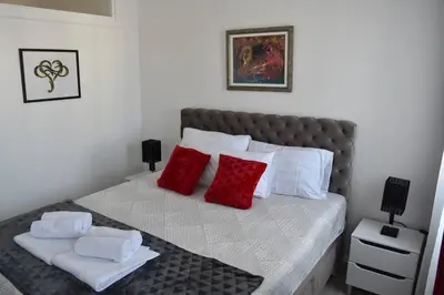 a bedroom with a bed with red and white pillows at Lux Apartman Crnjanski IV, Jagodina in Jagodina