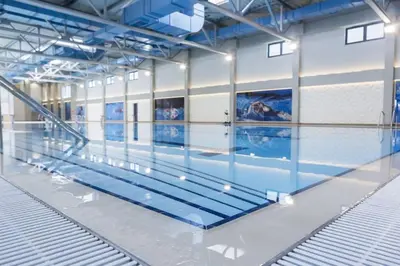a swimming pool in a building with a swimming poolvisorvisor at Lux Apartman Crnjanski IV, Jagodina in Jagodina