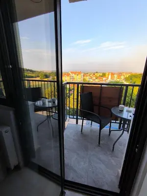 a balcony with two chairs and a table with a view at Lux Apartman Crnjanski IV, Jagodina in Jagodina