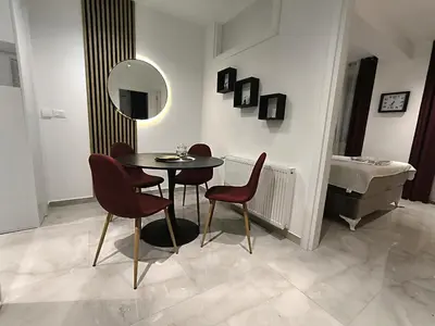 a dining room with a table and chairs and a mirror at Lux Apartman Crnjanski IV, Jagodina in Jagodina