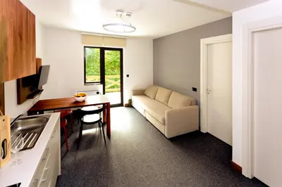 a kitchen and living room with a couch and a table at Vila Bela reka in Brzeće