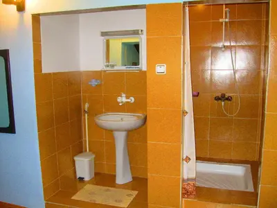 a small bathroom with a sink and a shower at Amfora Rooms Caribrod in Dimitrovgrad