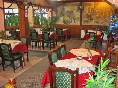 a restaurant with tables and chairs and a christmas tree at Amfora Rooms Caribrod in Dimitrovgrad