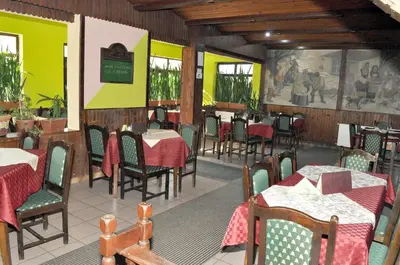 a dining room with tables and chairs in a restaurant at Amfora Rooms Caribrod in Dimitrovgrad