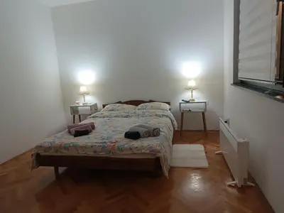 a bedroom with a bed and two lamps on two tables at Apartman 019 in Zaječar