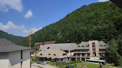 a large building with a mountain in the background at BeoKop Apartment in Brzeće