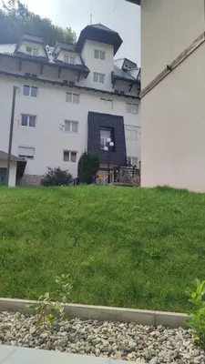 a building with a grassy yard next to a building at BeoKop Apartment in Brzeće