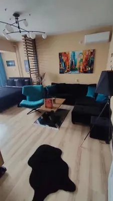 a living room with a black couch and blue chairs at Stan na dan Premium 030 in Bor
