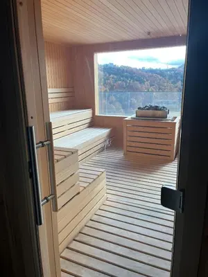 an empty sauna with a large window and a tub at Apartman Staša Zoned II in Kopaonik
