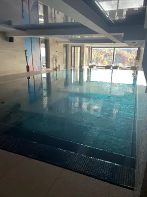a swimming pool with a glass floor in a building at Apartman Staša Zoned II in Kopaonik